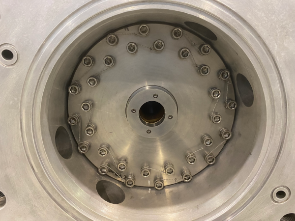 Circular industrial component with multiple hex bolts secured by safety wire